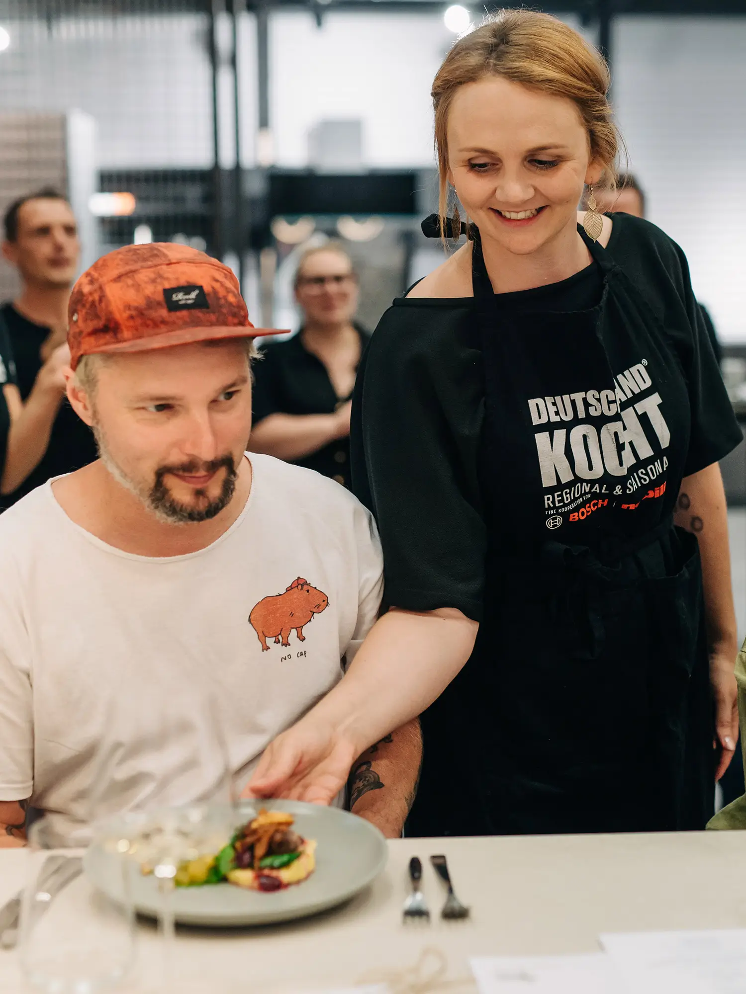 kochberater mit essen am zuschauer servieren