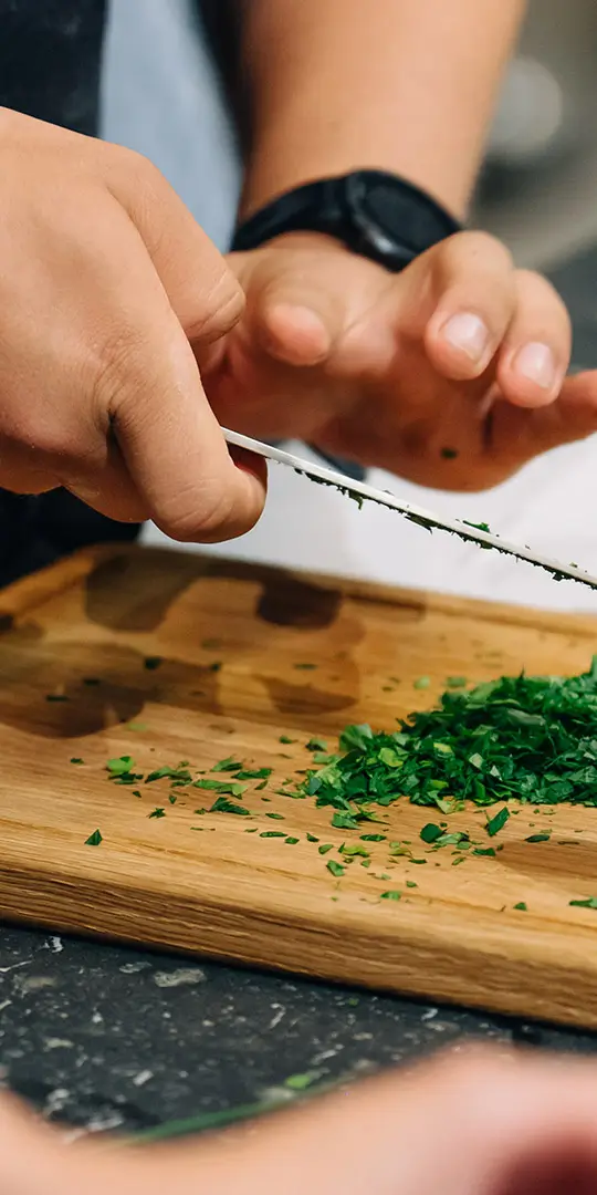 kochberater mit messer am essen vorbereiten